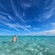 A man and a woman walking through shallow ocean water